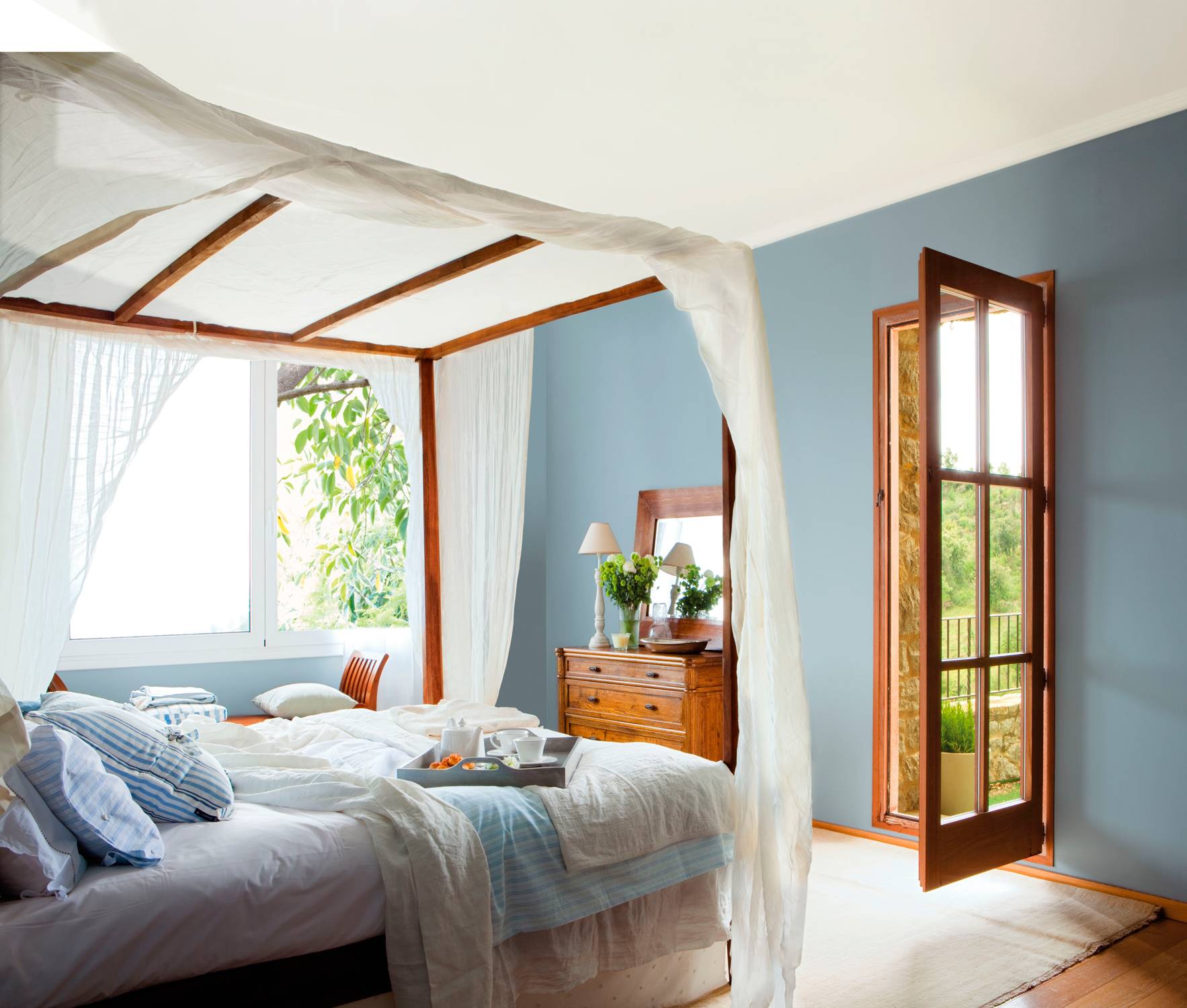 Blue bedroom with wooden canopy bed 00319828