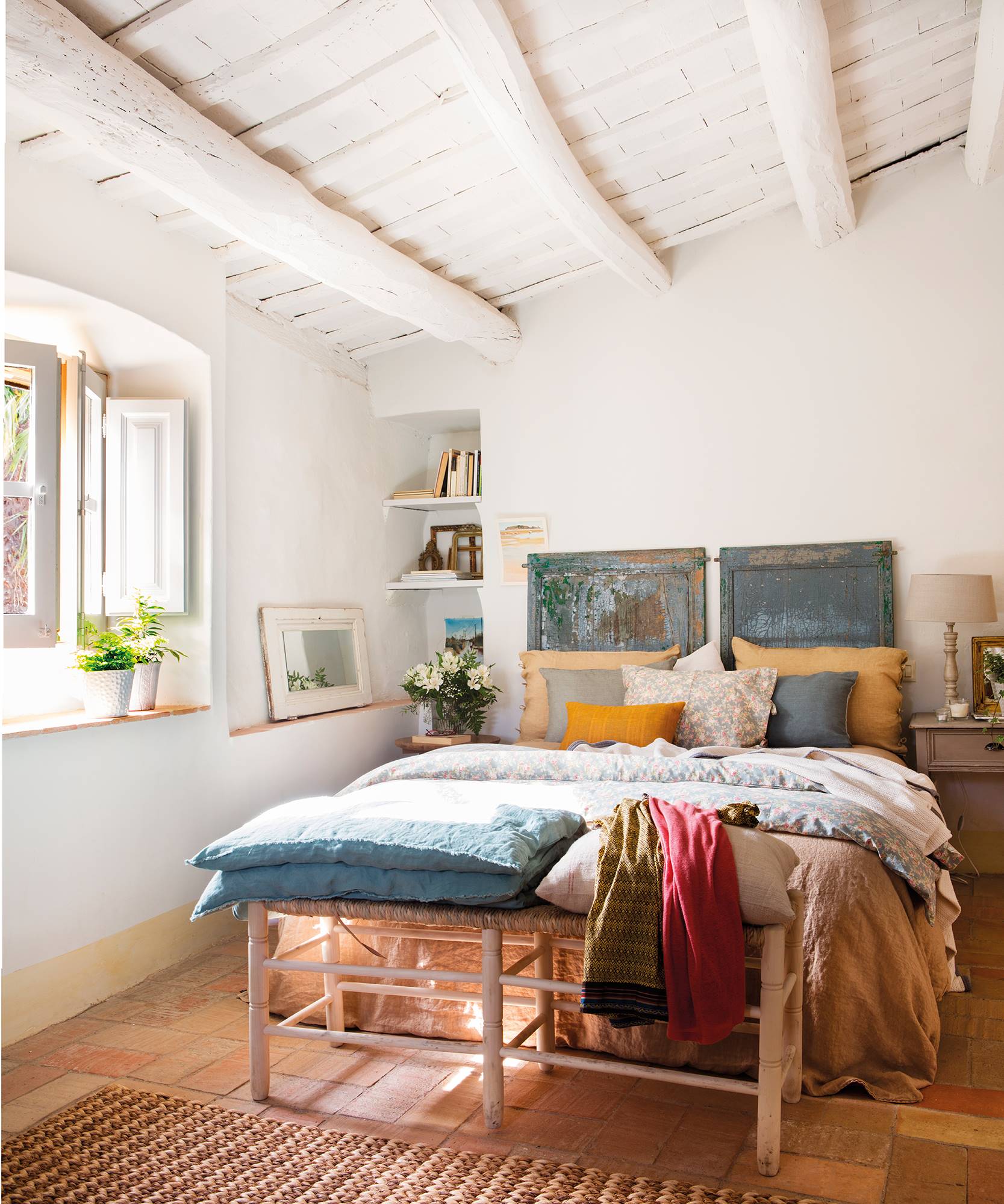 Rustic house bedroom with a blue door converted into a headboard